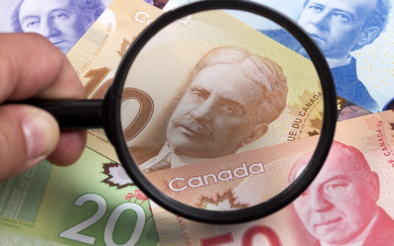 Magnifying glass over Canadian money